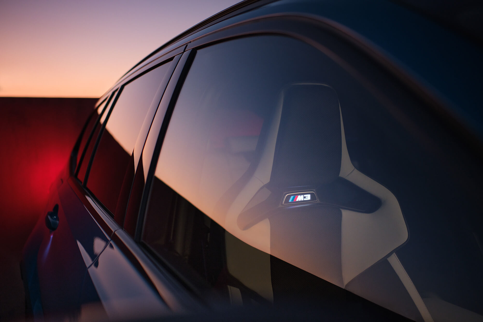 Sportiga säten i BMW M3 med belyst logga